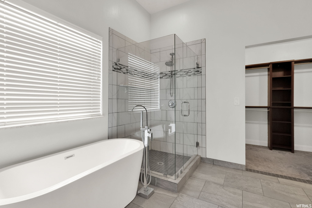 Bathroom featuring separate shower and tub and light tile flooring