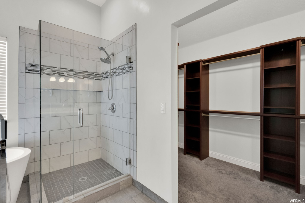 Bathroom with independent shower and bath and light tile flooring
