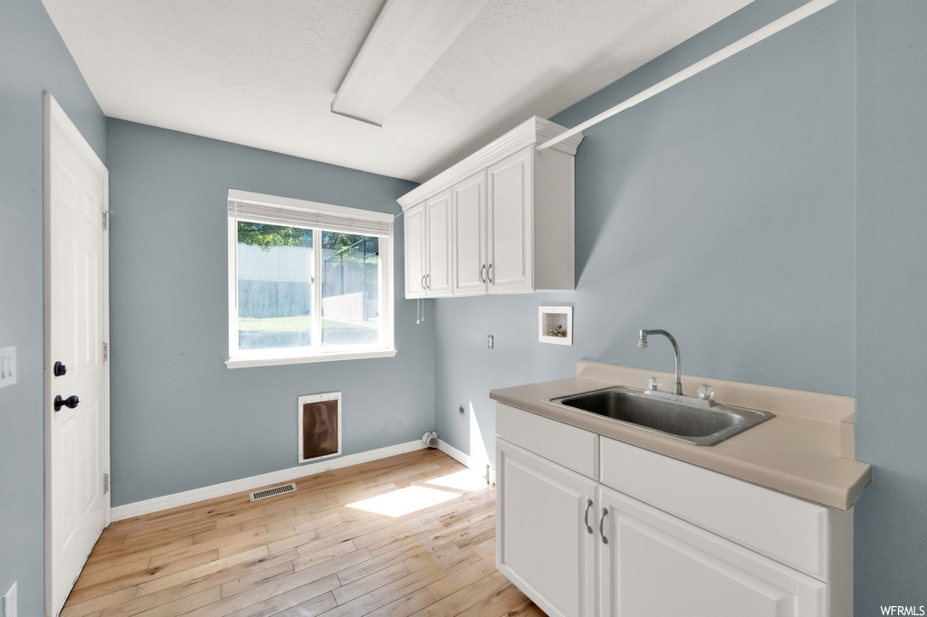 Laundry area featuring light hardwood floors