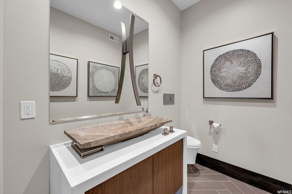 Bathroom with vanity, mirror, and light tile floors