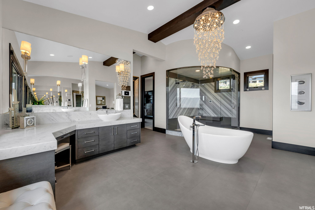 Bathroom with lofted ceiling with beams, a notable chandelier, a bath, vanity, and mirror