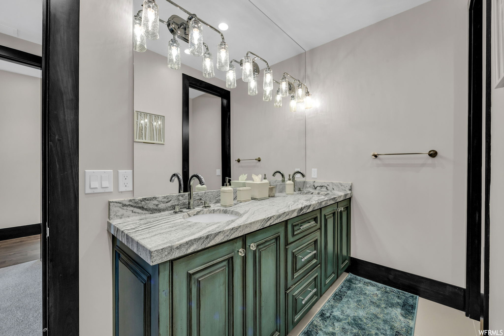 Bathroom featuring dark parquet floors, mirror, and double vanity
