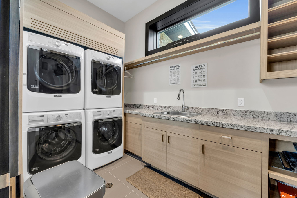Laundry area with light tile floors, stacked washer and clothes dryer, and washing machine and clothes dryer