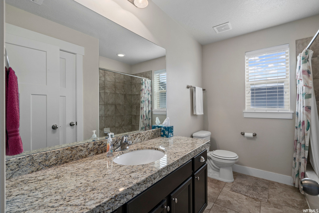 Full bathroom with shower / bath combination with curtain, vanity with extensive cabinet space, mirror, and tile flooring