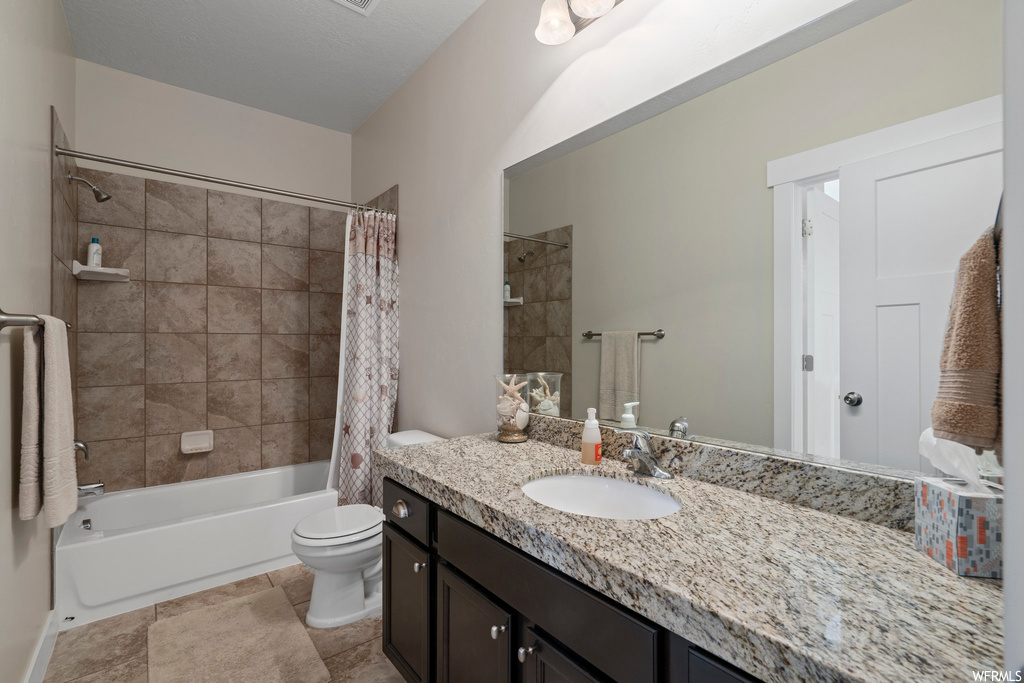 Full bathroom featuring shower / tub combo, oversized vanity, mirror, and light tile floors