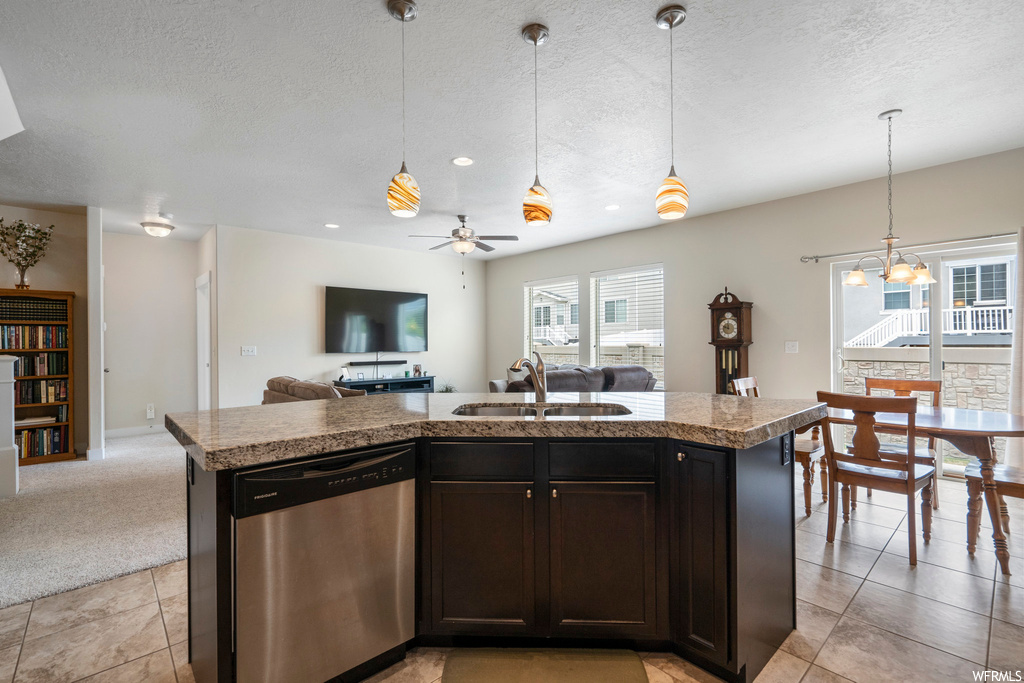 Kitchen featuring stone counters, pendant lighting, a textured ceiling, dark brown cabinets, stainless steel dishwasher, ceiling fan, and light tile flooring