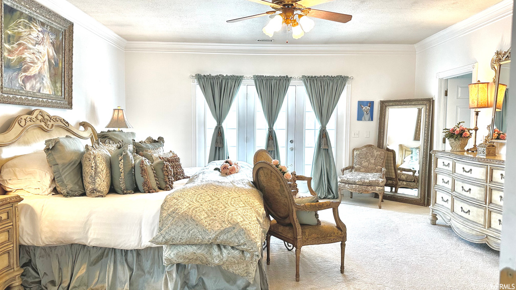 Carpeted bedroom with a textured ceiling, crown molding, and ceiling fan