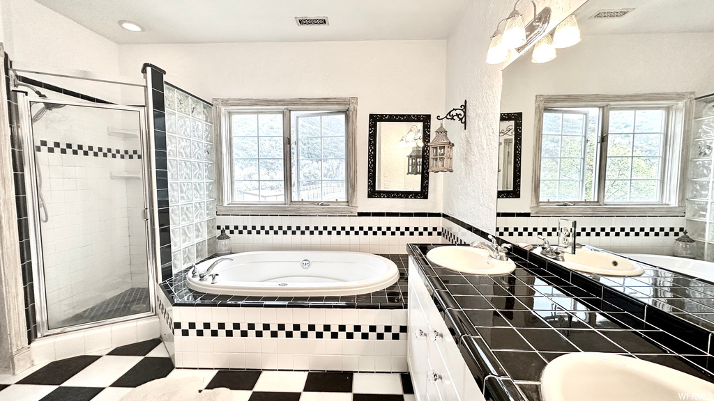 Bathroom featuring vanity, separate shower and tub enclosures, mirror, and tile flooring