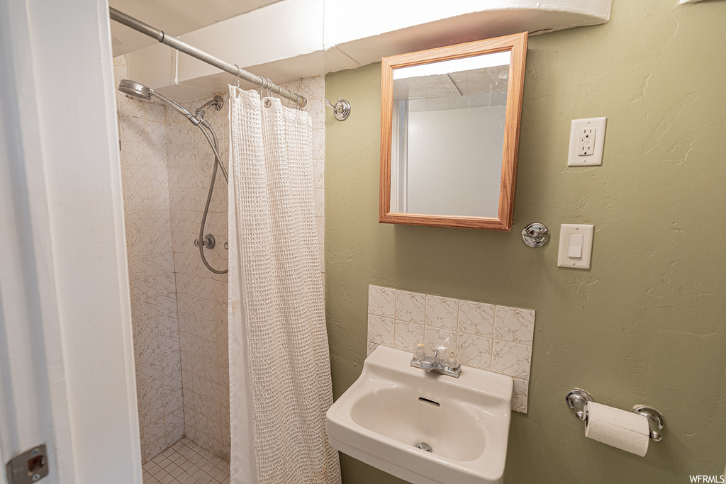Bathroom featuring sink and curtained shower