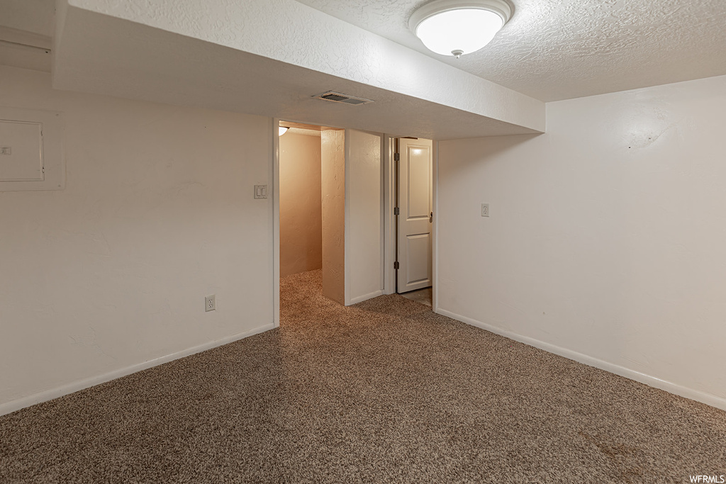 Basement featuring carpet and a textured ceiling