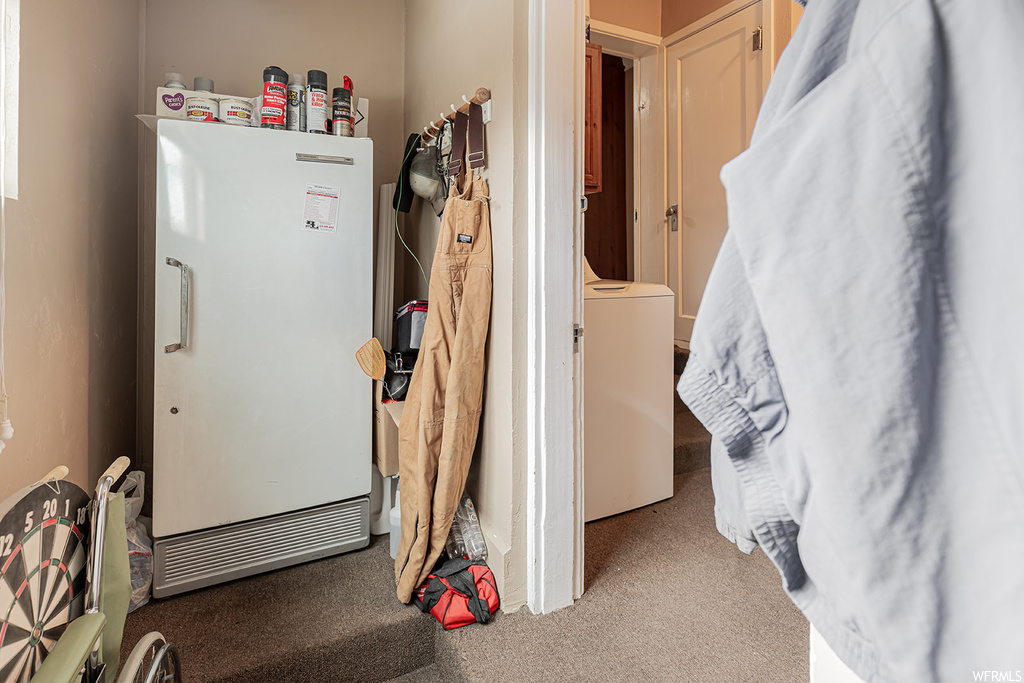 Interior space featuring washer / clothes dryer, refrigerator, and carpet flooring