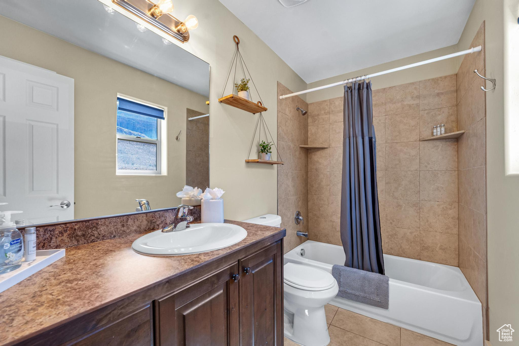 Full bathroom featuring shower / bath combo, vanity with extensive cabinet space, tile floors, and toilet