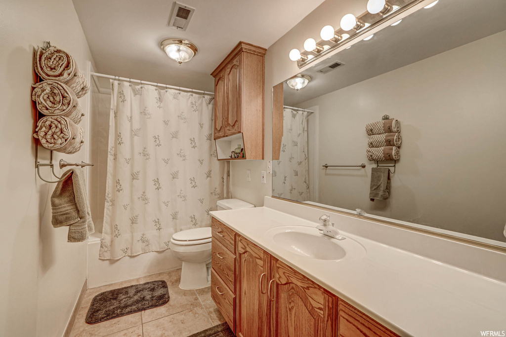 Full bathroom with shower / tub combo, light tile floors, vanity, and mirror