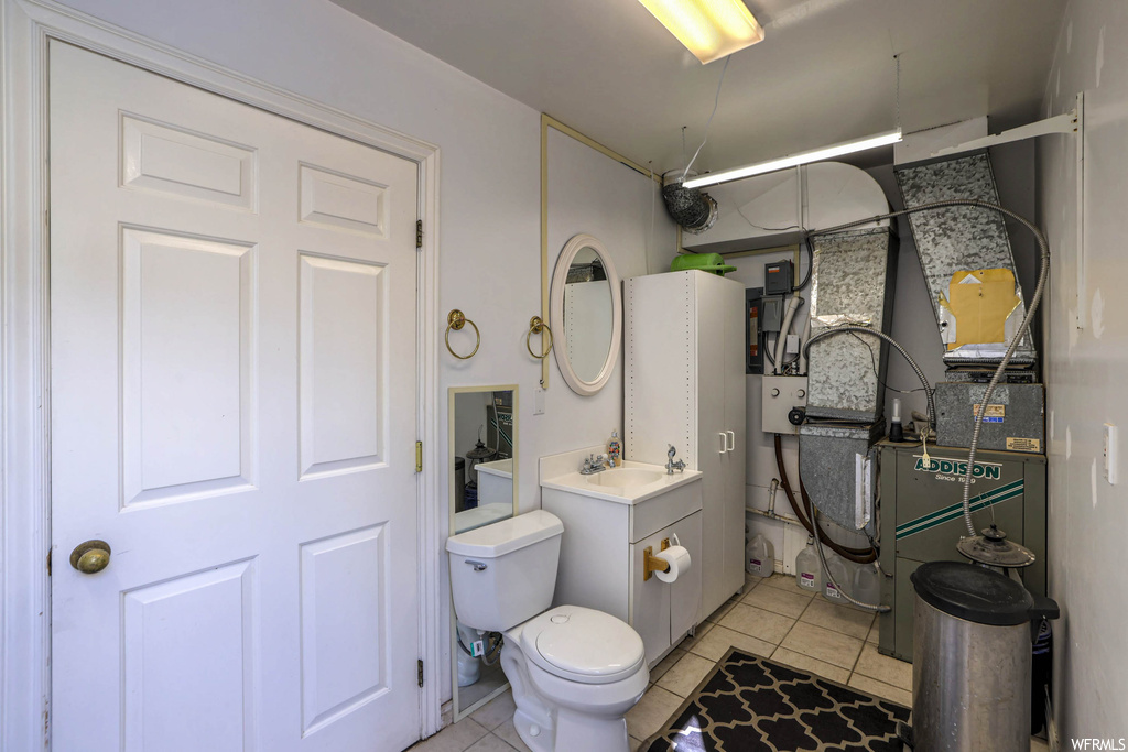 Bathroom featuring vanity, mirror, and light tile floors