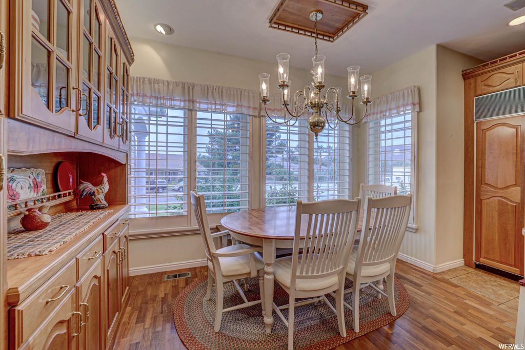 Dining room featuring hardwood floors and a notable chandelier