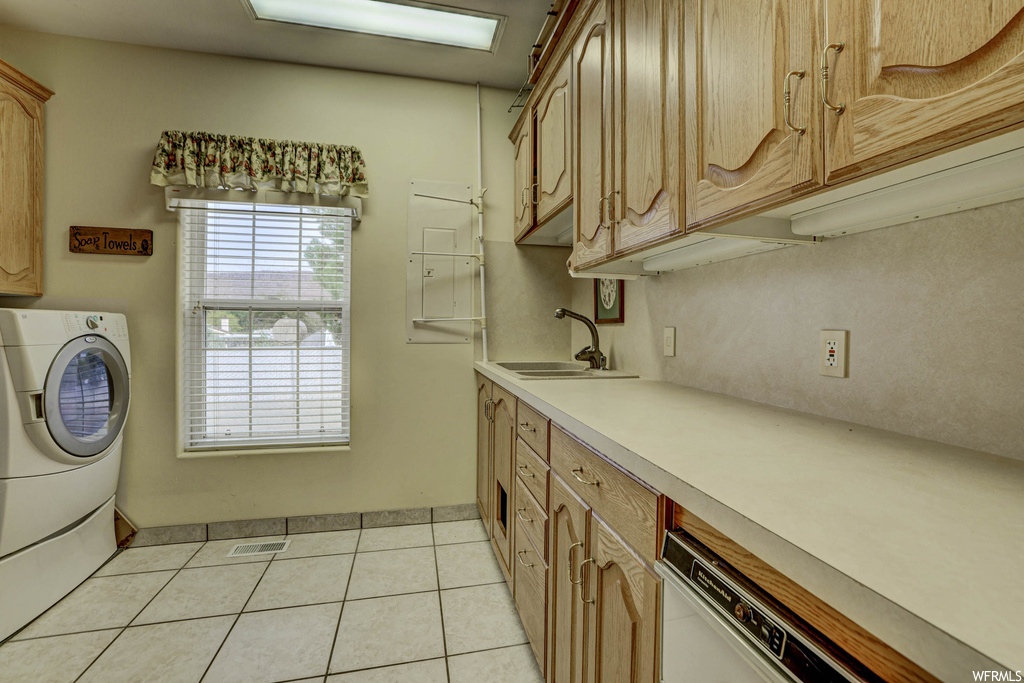 Kitchen with light countertops, light tile flooring, and washer / clothes dryer