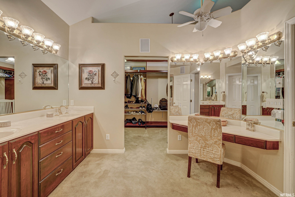 Bathroom featuring double large sink vanity, ceiling fan, and mirror