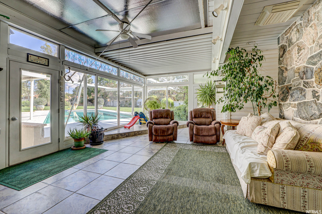 Sunroom / solarium with beamed ceiling and ceiling fan