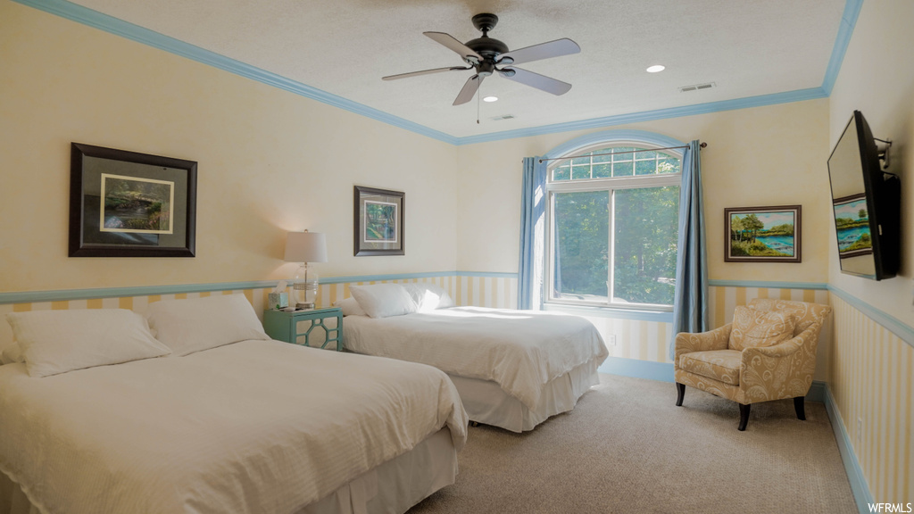 Bedroom featuring crown molding, ceiling fan, and light carpet
