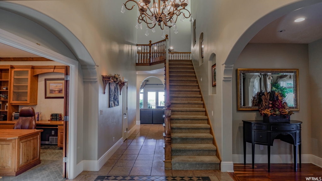 Stairway featuring light hardwood floors and a notable chandelier