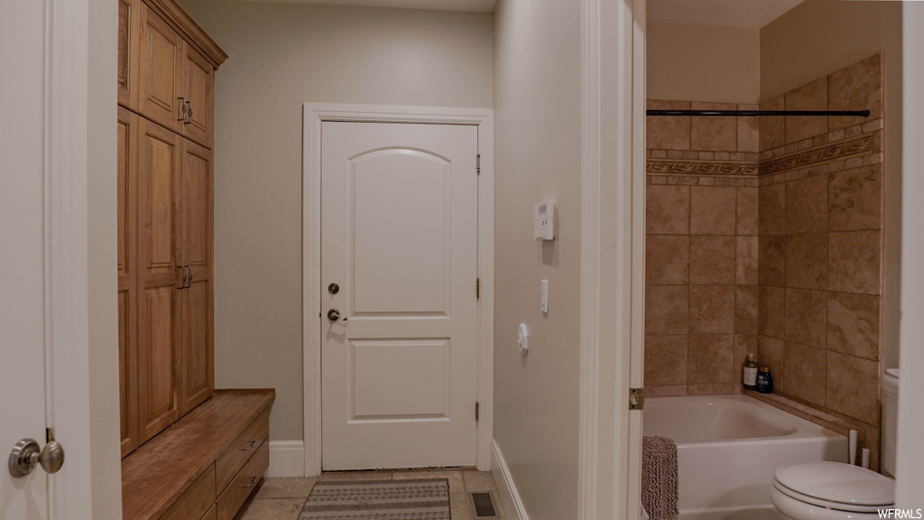 Bathroom with light tile flooring and tiled shower / bath