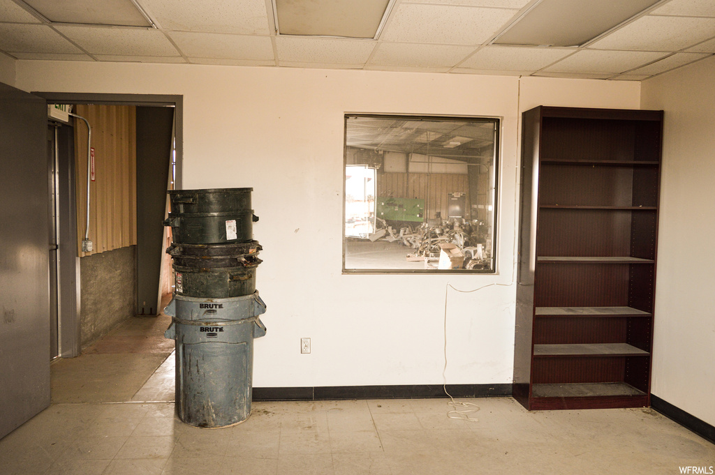 Interior space with a drop ceiling and light tile floors