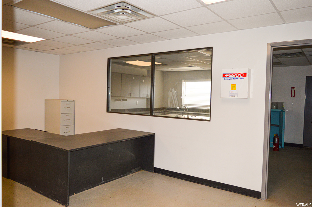Interior space with a drop ceiling and concrete floors