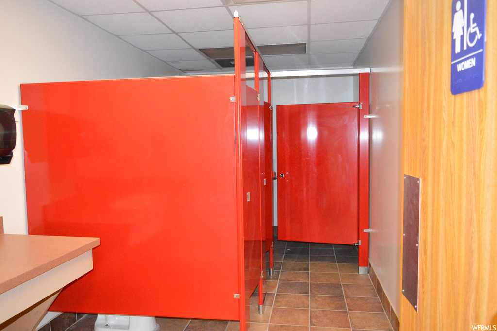 Corridor with a drop ceiling and tile flooring