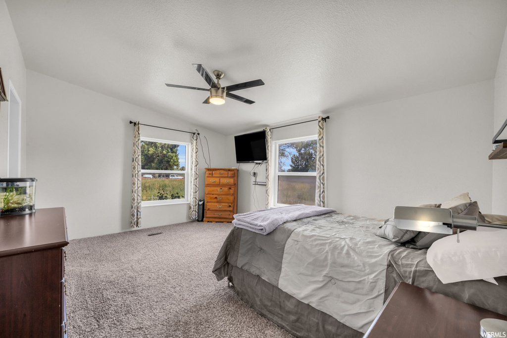 Bedroom featuring light carpet, ceiling fan, and vaulted ceiling