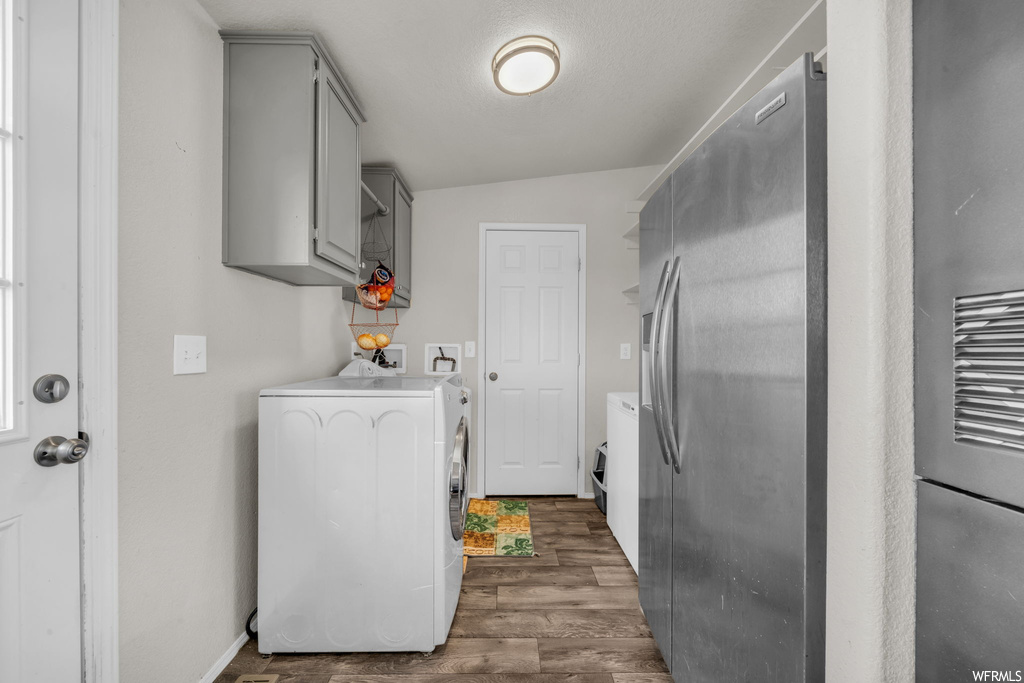 Laundry area featuring dark hardwood flooring and washer / clothes dryer