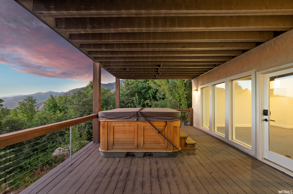 Deck at dusk featuring hot tub