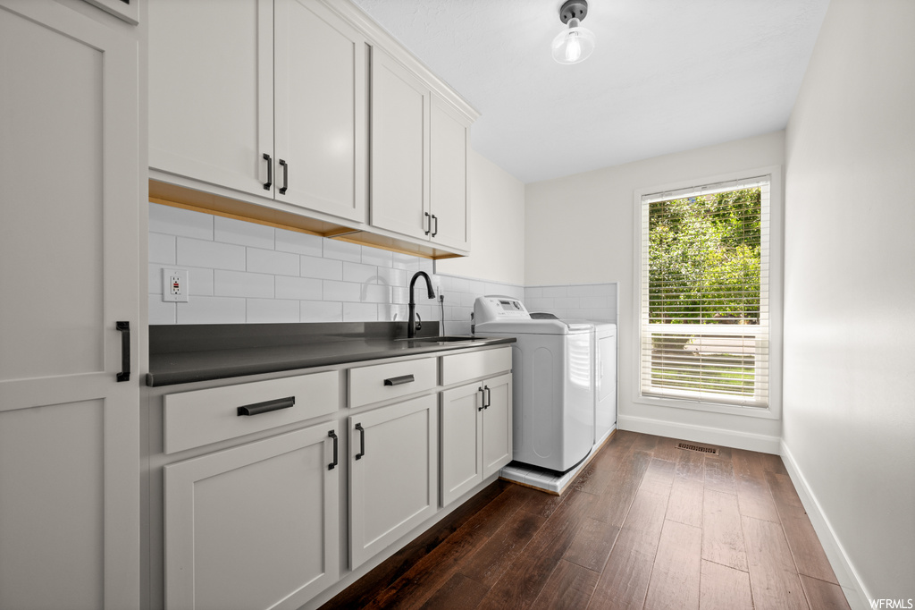 Kitchen featuring backsplash, white cabinets, wood-type flooring, and dark countertops