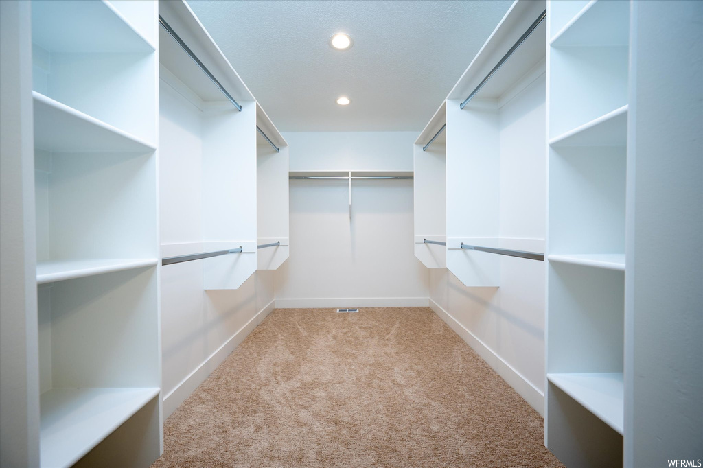 Spacious closet with light colored carpet