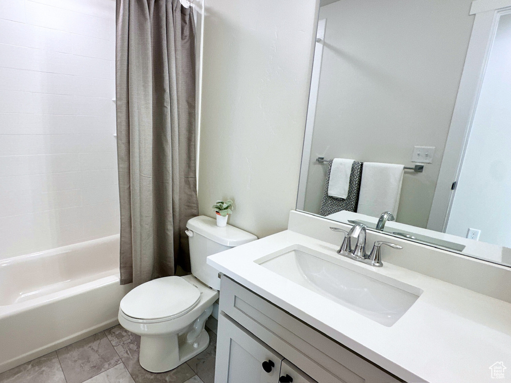 Full bathroom featuring vanity, tile patterned flooring, toilet, and shower / tub combo with curtain