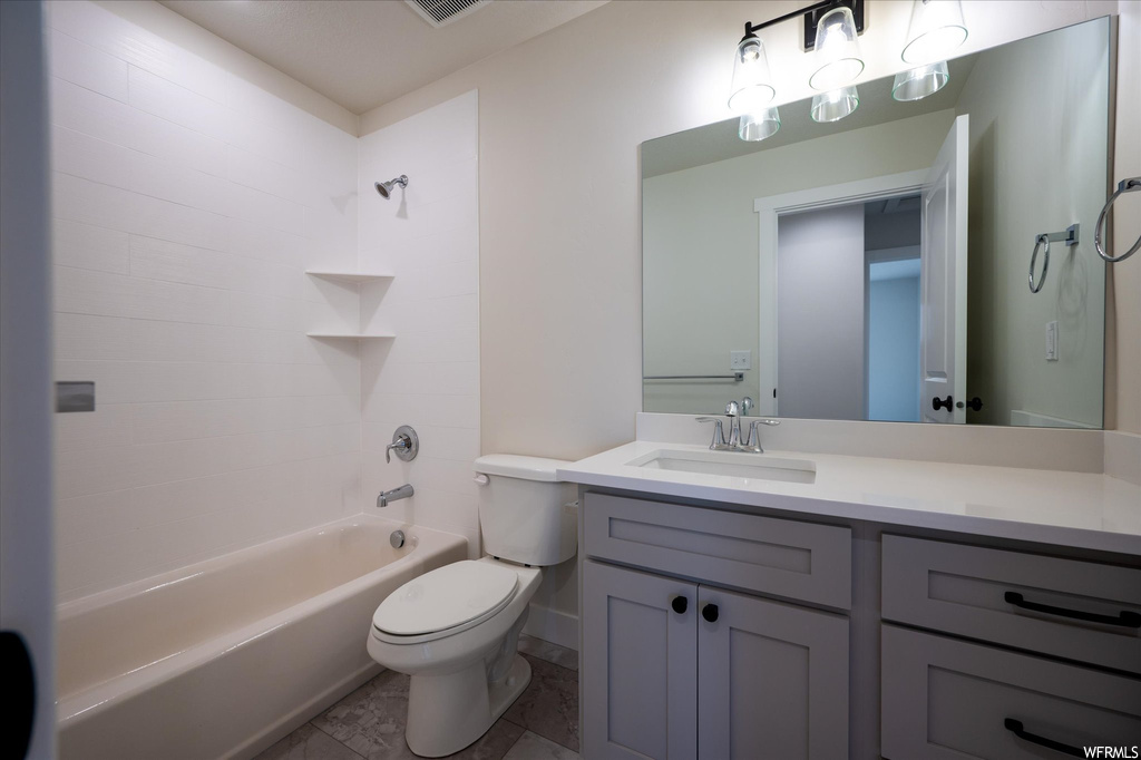 Full bathroom with tub / shower combination, vanity, toilet, and tile floors