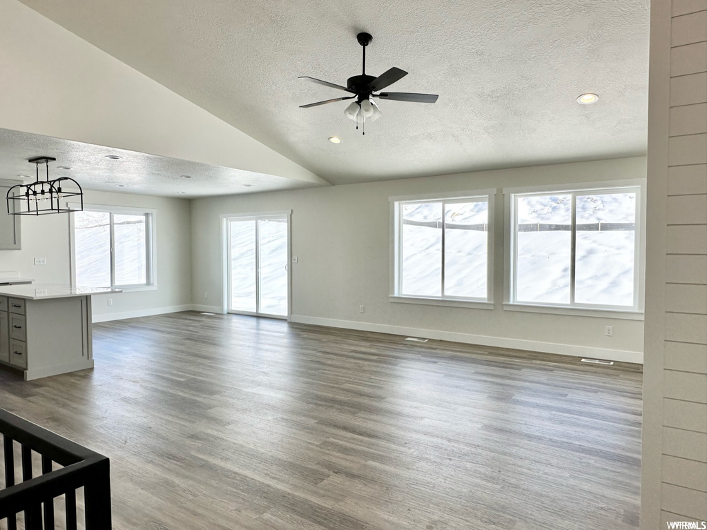 Unfurnished room featuring plenty of natural light, ceiling fan, light hardwood flooring, and lofted ceiling
