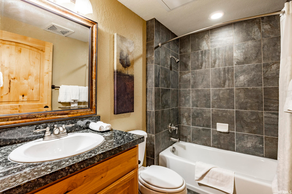 Full bathroom featuring shower / tub combo, vanity with extensive cabinet space, and mirror