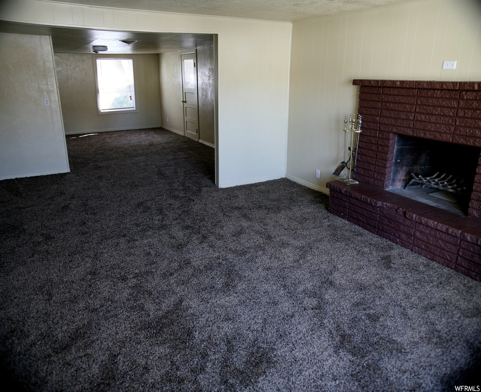 Living room with a fireplace and dark carpet