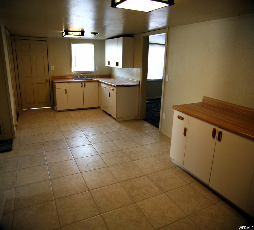 Kitchen featuring light tile flooring and light countertops