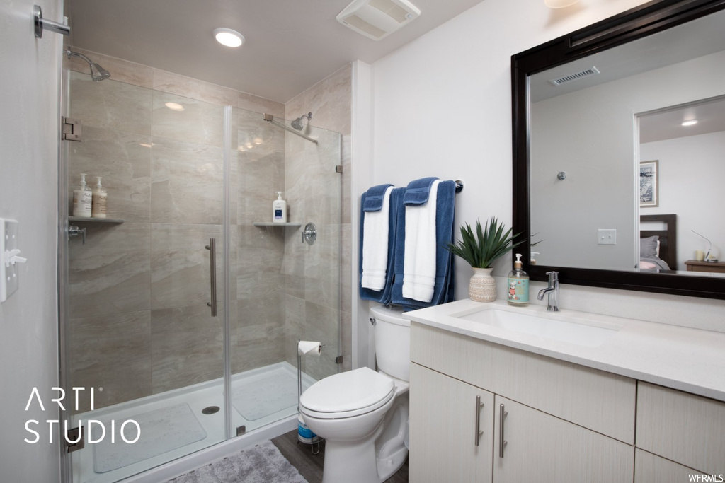 Bathroom with vanity, mirror, and a shower with shower door