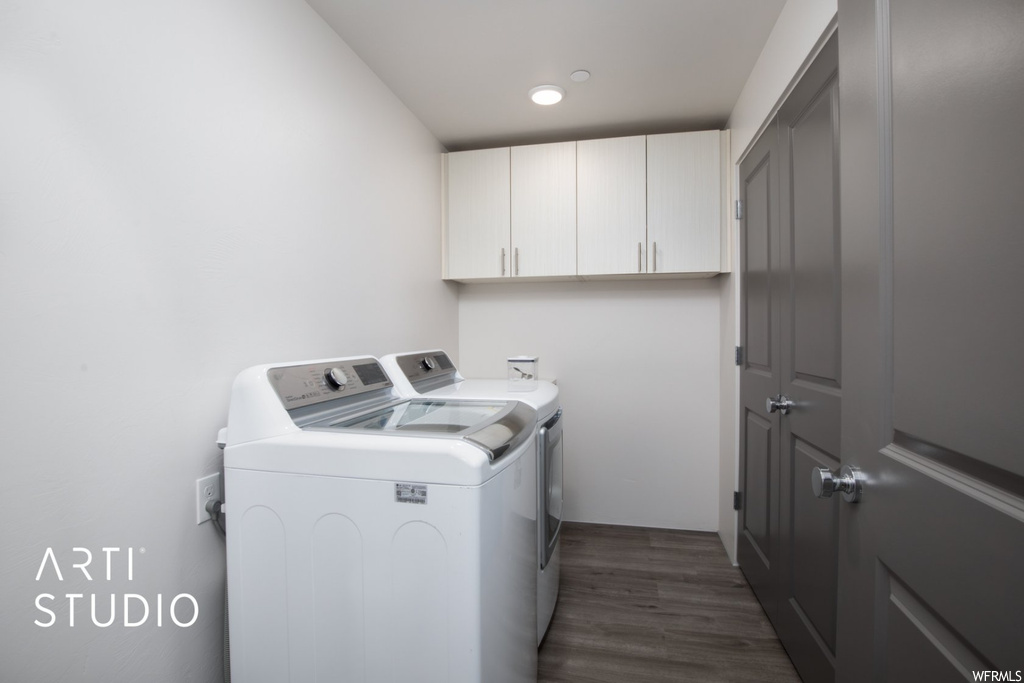 Laundry room featuring dark hardwood flooring and washing machine and dryer