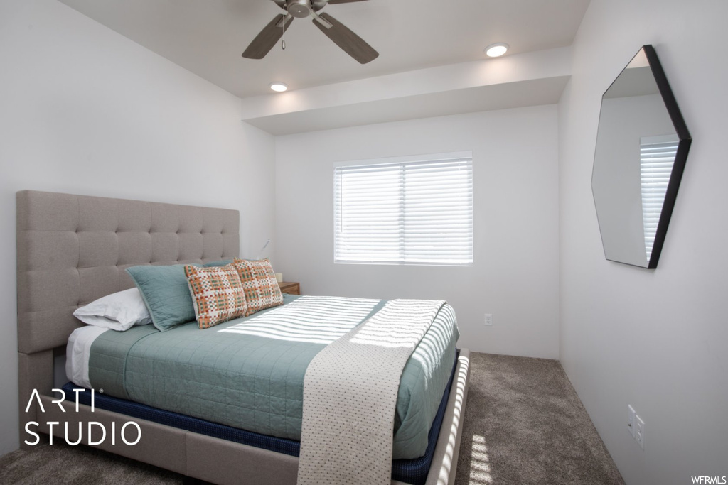 Bedroom with ceiling fan and dark carpet