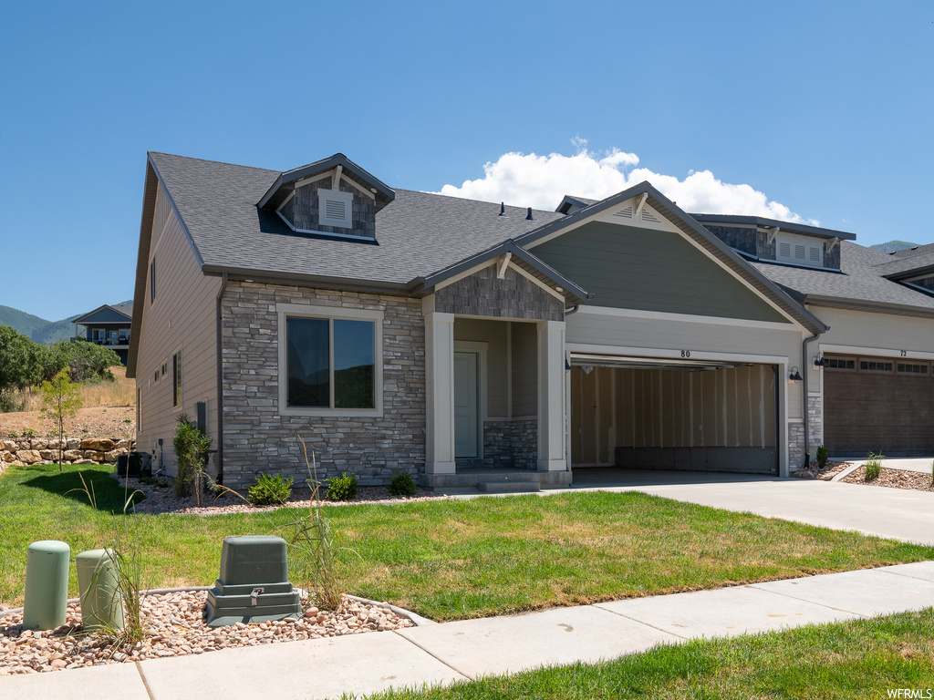 Craftsman inspired home featuring garage and a front yard
