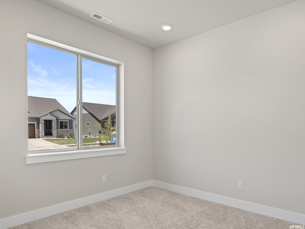 Unfurnished room featuring light carpet