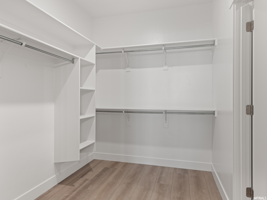 Wardrobe featuring light hardwood floors