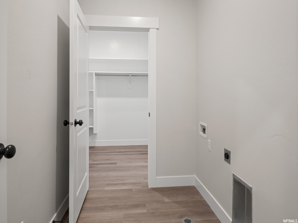 Laundry room with light hardwood flooring