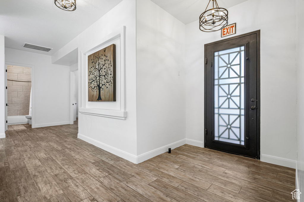 Entryway with a notable chandelier and light hardwood / wood-style flooring