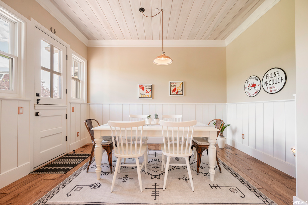 Hardwood floored dining space featuring ornamental molding