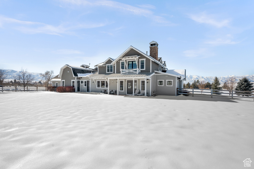 Snow covered property with a mountain view