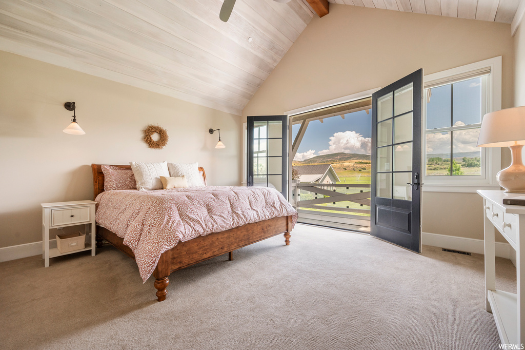 Bedroom with light carpet and vaulted ceiling with beams